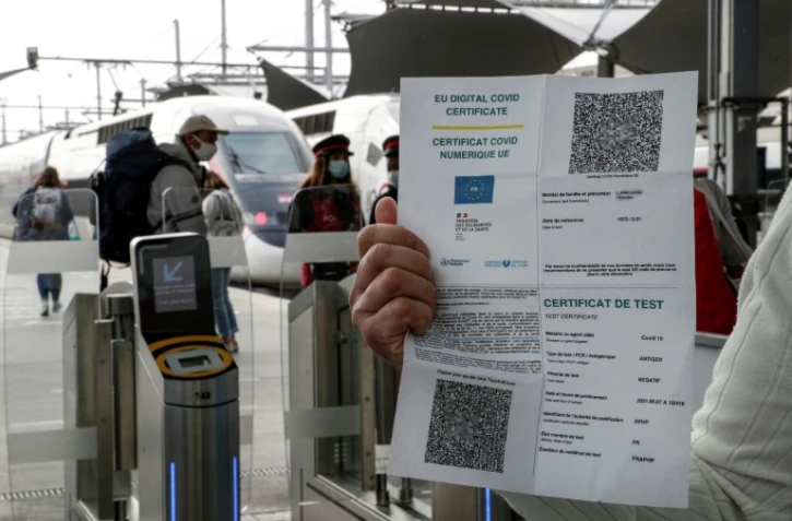 Un passager présente son pass sanitaire avant d'accéder au quai, lundi 9 août 2021, gare de Lyon à Paris