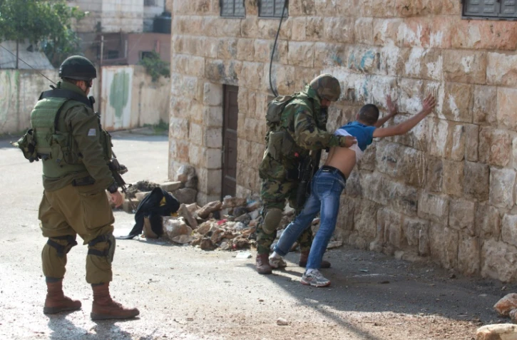 Des soldats israéliens fouillent un Palestinien, le 29 octobre 2015 à Hébron, en Cisjordanie