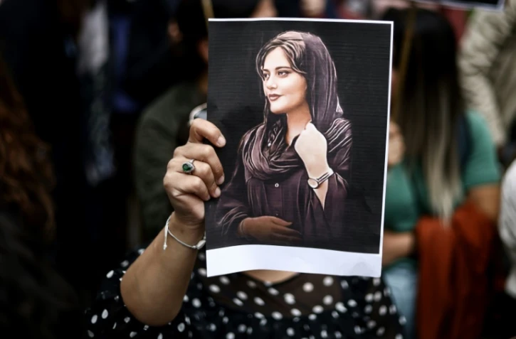 Une femme tient un portrait de Mahsa Amini lors d'une manifestation devant l'ambassade d'Iran à Bruxelles, le 23 septembre 2022