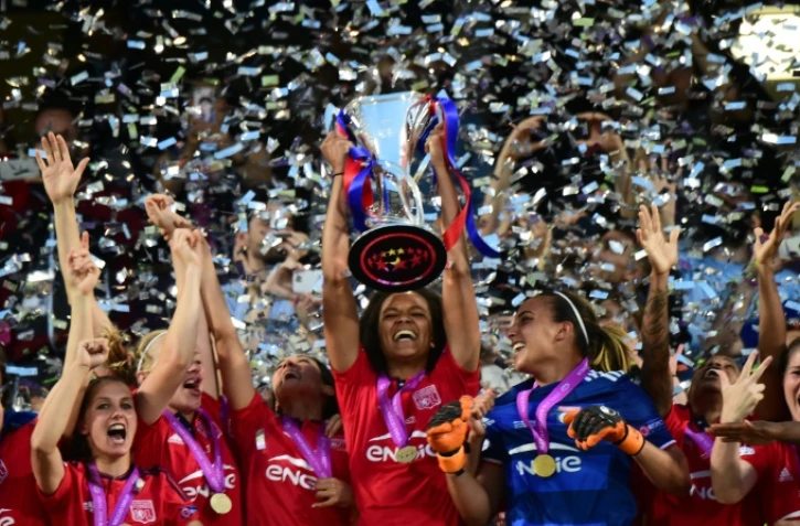 La capitaine de l'Olympique de Lyon Wendie Renard brandit le trophée après la victoire face à Wolfsburg en finale de Ligue des champions, le 26 mai 2016 à Reggio Emilia (Italie)
