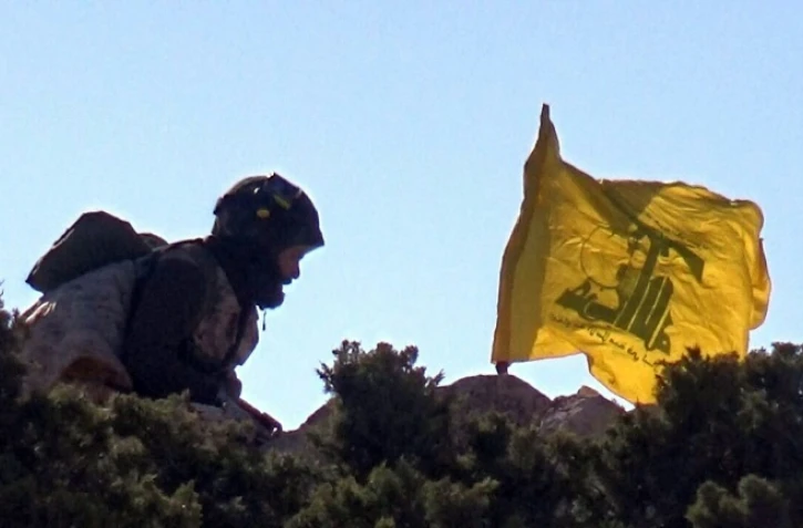 Photo fournie par le service de presse du Hezbollah en mai 2015 d'un combattant du Hezbollah érigeant le drapeau du mouvement en Syrie près de Qalamun
