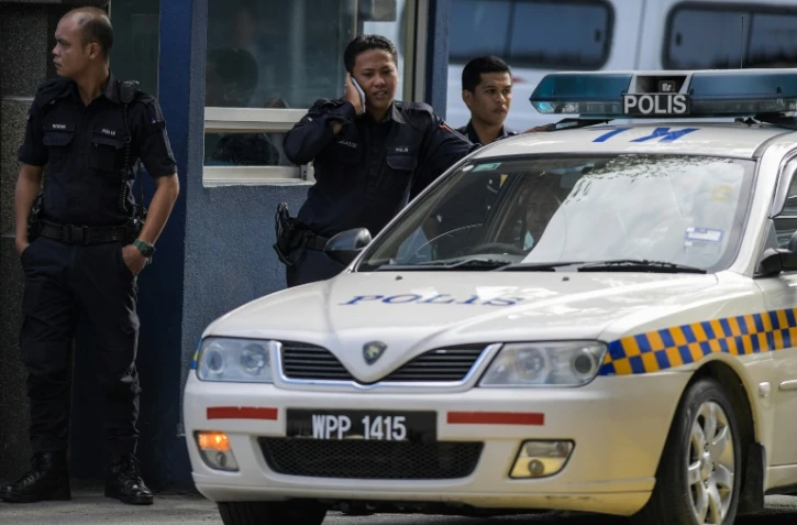 Des policiers devant l'entrée du bâtiment de médecine légale de l'hôpital de Kuala Lumpur, le 17 février 2017, où se trouve le corps de Kim Jong-Nam, demi-frère du leader nord-coréen Kim Jong-Un, assassiné lundi en Malaisie