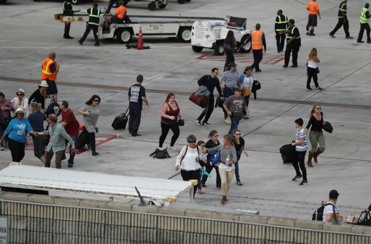 Des voyageurs fuient pour se mettre à l'abri sur le tarmac de l'aéroport de  Lauderdale-Hollywood après une fusillade mortelle, le 6 janvier 2017 
