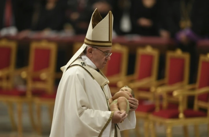 Le pape François porte une statue de l'enfant Jésus lors d'une messe à la veille de Noël, au Vatican, le 24 décembre 2016