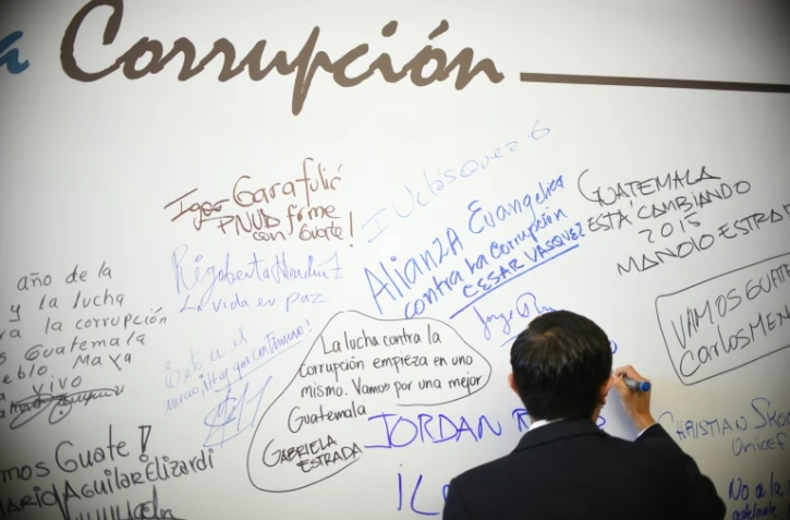 Un homme écrit sur un mur lors d'une journée de lutte anticorruption à Guatemala, le 9 décembre 2015