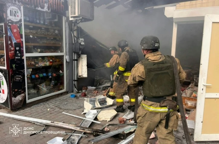Photo prise et distribuée le 4 avril 2026 par le ministère des situations d'urgence ukrainien montrant des pompiers en train d'éteindre un incendie sur un marché après une frappe à Nikopol, dans le centre-est du pays