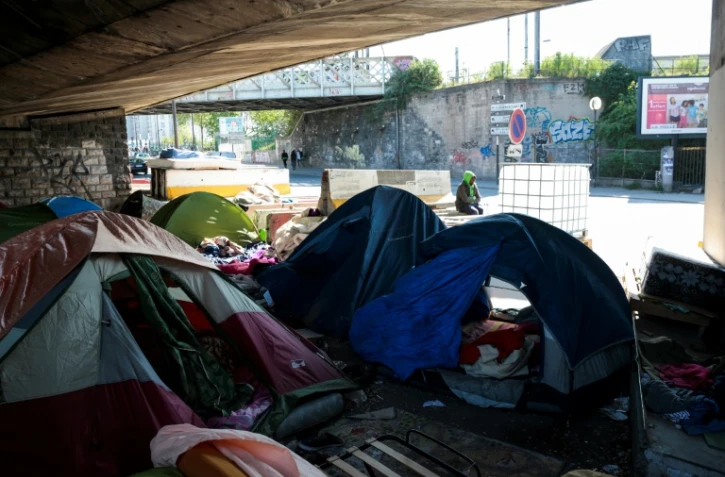 Un homme assis dans un camp de fortune de migrants sous une autoroute à la Porte de la Chapelle à Paris, le 19 avril 2017
