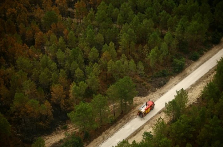 Vue aérienne depuis un hélicoptère de la sécurité civile montrant un camion de pompiers sur une route à Le Porge, en Gironde, le 31 juillet 2026