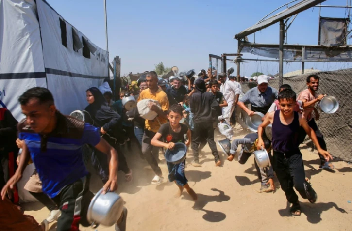 Des Gazaouis se ruent sur une distribution d'aide alimentaire à Khan Younès, dans le sud de la bande de Gaza, le 22 juillet 2025