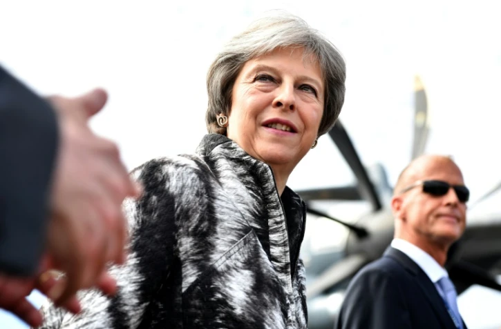 La Première ministre britannique Theresa May (c) arrive au salon de Farnborough, dans le sud-ouest de Londres, accompagnée du patron d'Airbus Tom Enders (d), le 16 juillet 2018