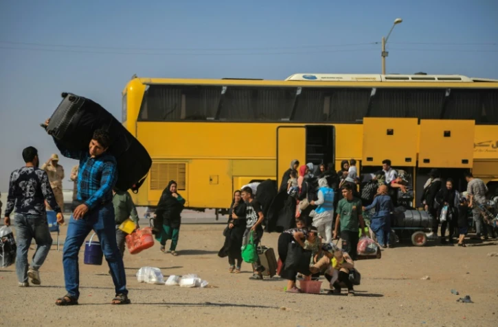 Un bus iranien dépose des réfugiés afghans à la frontière d'Islam Qala, dans la province d'Herat, le 24 juillet 2025 en Afghanistan