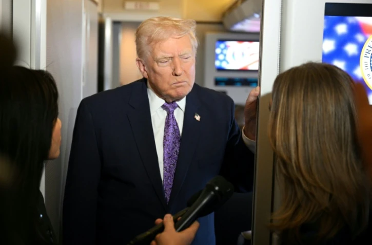 Le président américain Donald Trump parle à la presse à bord d'Air Force One avant son arrivée à la base aérienne Andrews près de Washington, le 30 novembre 2025