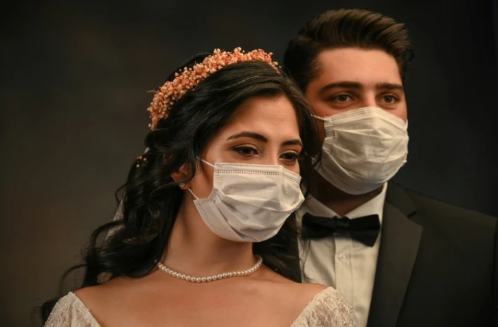 La Turque de 28 ans Ayse Keles et son mari Alp Colak posent masqués pour leurs photos de mariage le 5 septembre 2020 à Istanbul