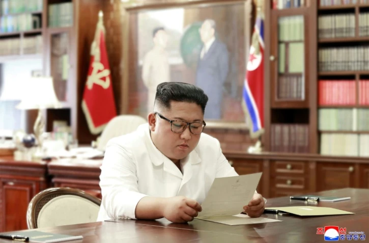 Une photographie de l'agence officielle nord-coréenne KCNA publiée le 23 juin 2019 montre Kim Jong Un lisant une lettre de Donald Trump
