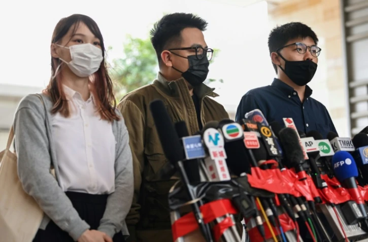 De gauche à droite: les militants pro-démocratie Agnes Chow, Ivan Lam et Joshua Wong parlent aux journalistes avant leur procÚs à Hong Kong, le 23 novembre 2020