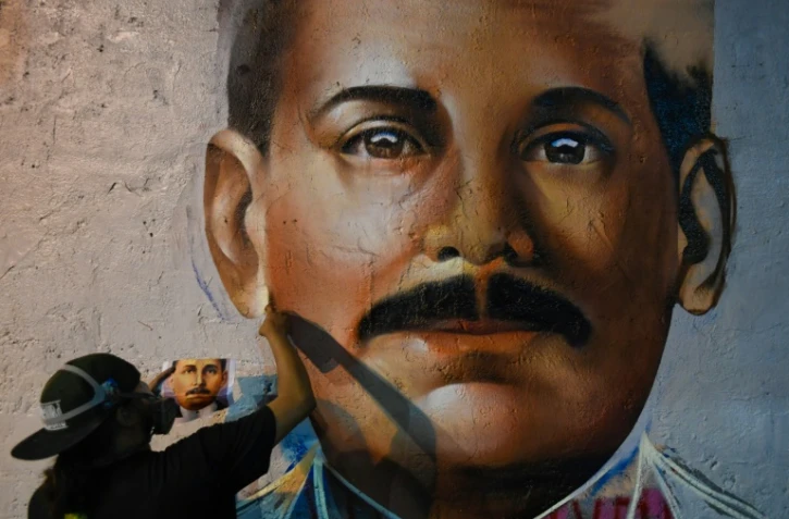 Le graffeur Wolfgang Salazar, alias Badsura, met la touche finale à un portrait du médecin vénézuélien Jose Gregorio Hernandez sur un mur de Caracas, le 27 avril 2021