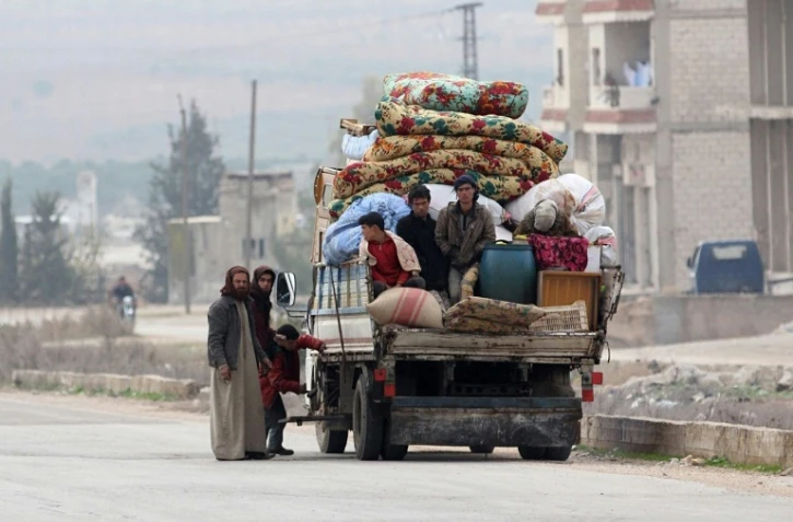 Une famille fuit les combats à la périphérie de la province syrienne d'Idleb entre régime et jihadistes, le 29 décembre 2017