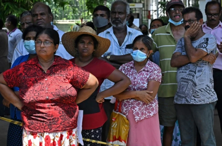 Des Srilankais font la queue devant une station de service de Colombo pour remplir leurs bombonnes de GPL, le 14 juillet 2022