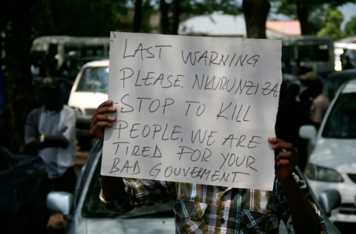 Une pancarte sur laquelle on peut lire "Dernier avertissement Nkurunziza, cessez de tuer des gens, nous en avons assez de votre mauvais gouvernement", brandie par un manifestant lors des funérailles d'un journaliste à Bujumbura le 20 octobre 2015