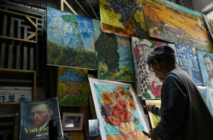 Un artiste peint une copie du tableau "Tournesols" de Vincent Van Gogh dans une allée du village de Dafen, le 19 février 2023 en Chine