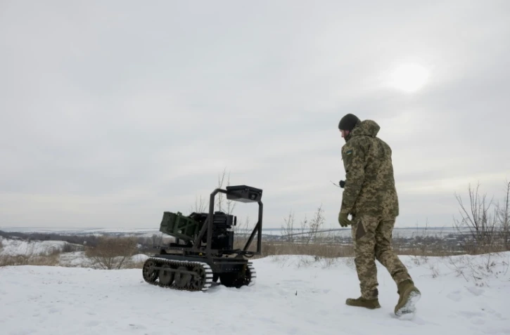Un militaire ukrainien de la 30e brigade mécanisée indépendante prépare un véhicule terrestre robotisé sans pilote armé d'un lance-grenades Mk 19 pour un test dans un lieu non divulgué de la région de Donetsk le 27 janvier 2026.