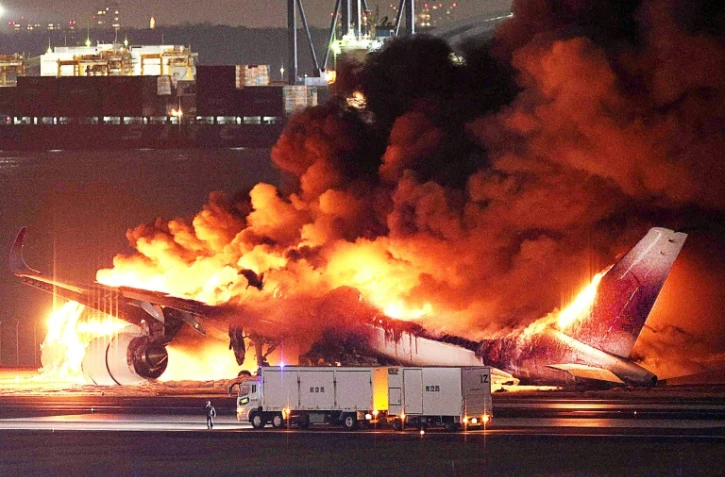 Un avion de la Japan Airlines en feu sur le tarmac de l'aéroport international de Tokyo-Haneda le 2 janvier 2024, après une collision avec un avion des garde-côtes japonais
