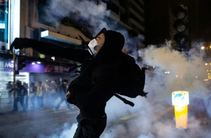 Un manifestant dans un nuage de gaz lacrymogènes tiré par la police, le 25 décembre 2019 à Hong Kong
