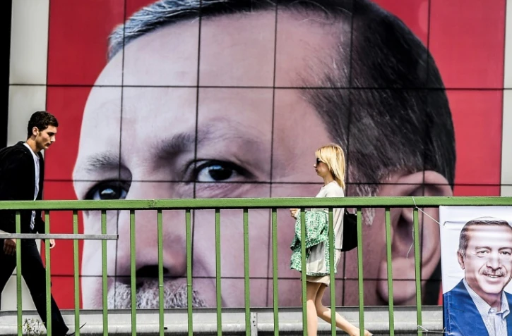 Des personnes marchent devant une affiche du président Recet Tayyip Erdogan le 6 avril 2017 à Istanbul