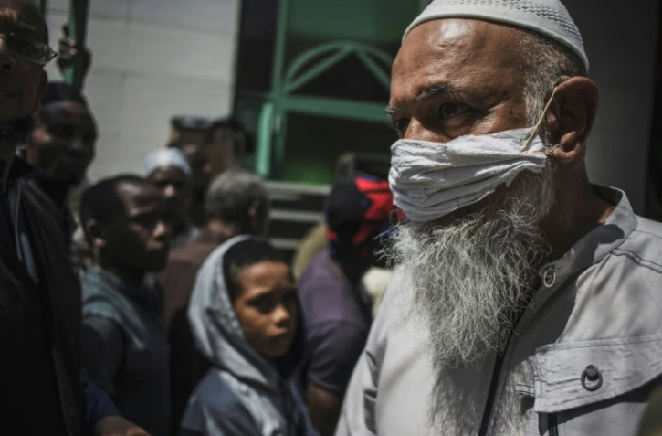 Un fidèle musulman portant un masque de protection artisanal quitte la mosquée de la 23e rue dans le quartier de Mayfair, à Johannesburg, le 20 mars 2020.
