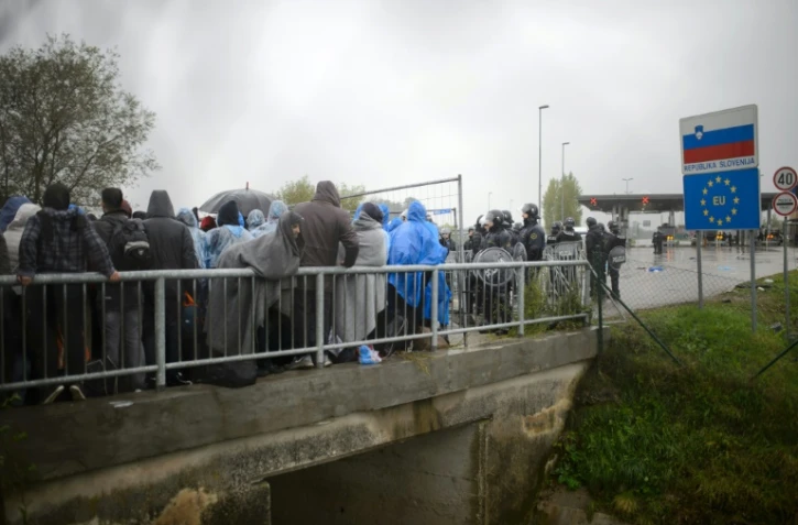 Des migrants attendent le 19 octobre 2015 d'être autorisés à la frontière entre la Croatie et la Slovénie à passer en territoire slovène