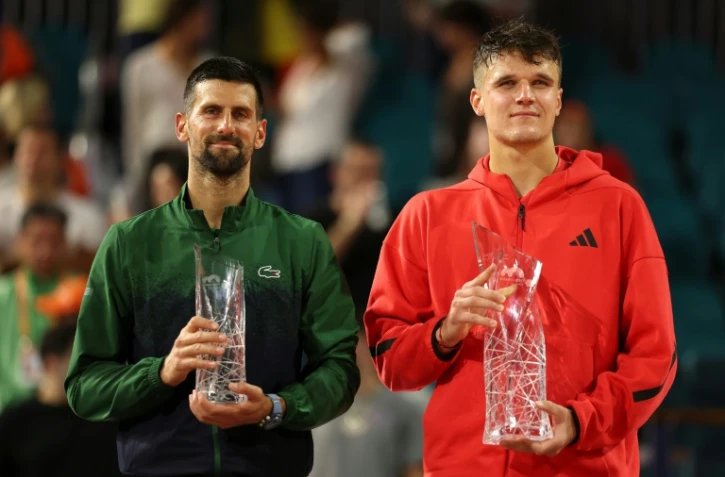 Le Serbe Novak Djokovic (g.) et le Tchèque Jakub Mensik posent avec leurs trophées après la finale du Masters 1000 de Miami, à Miami Gardens, le 30 mars 2025