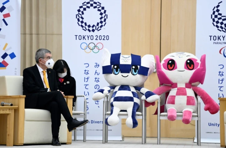 Le président du Comité international olympique (CIO), Thomas Bach, assis à côté des mascottes des Jeux olympiques et paralympiques de Tokyo-2020, reportés en 2021, le 16 novembre 2020 à Tokyo