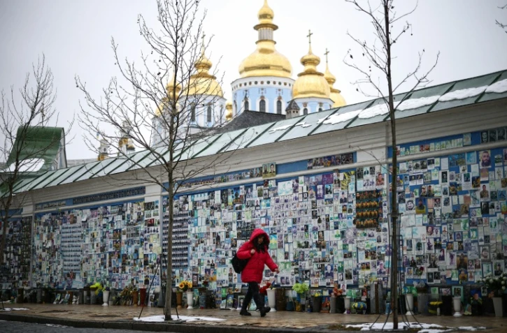 Une personne passe devant le Mur du Souvenir des Morts pour l'Ukraine à Kiev, le 25 février 2026