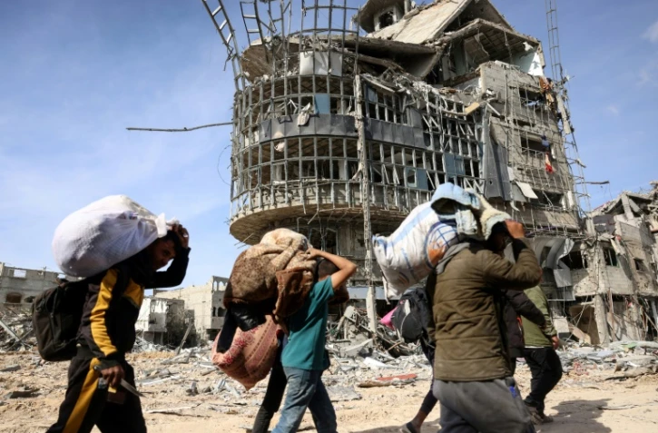 Des déplacés palestiniens avec leurs effets personnels retournent chez eux à Rafah, dans le sud de la bande de Gaza, au milieu des destructions, le 19 janvier 2025
