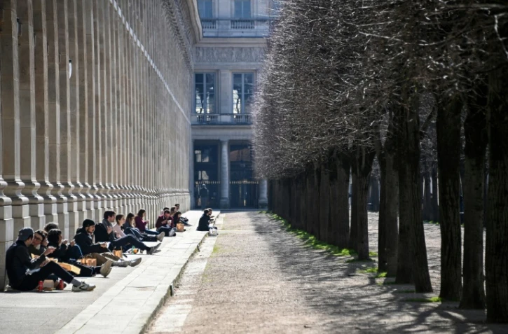 Des personnes prennent le soleil au Palais Royal le 20 mars 2021