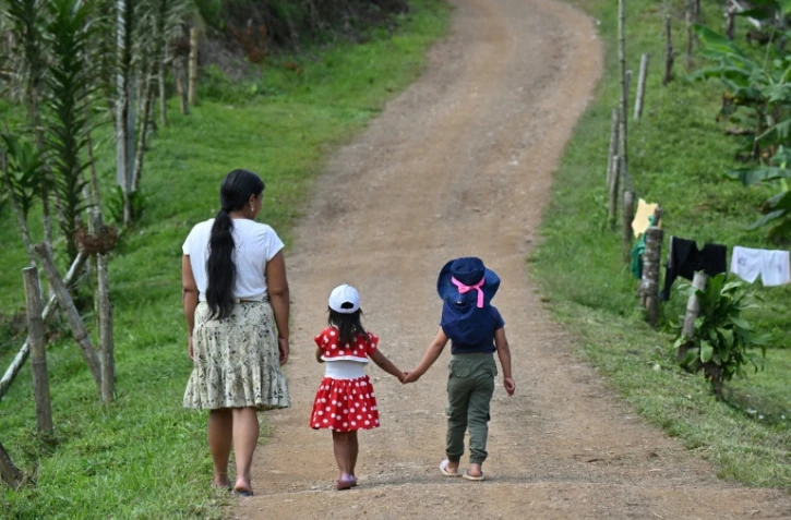 Francia Giraldo, une femme autochtone embera chami et dirigeante communautaire, marche avec ses petites-filles dans une réserve de Pueblo Rico, en Colombie, le 9 avril 2026