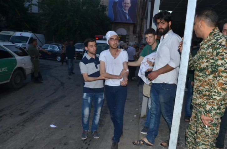 Un homme blessé marche dans la rue après un raid aérien contre un hôpital et un immeuble résidentiel contrôlés par la rébellion à Alep, le 27 avril 2016