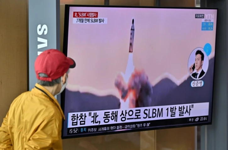 Passant regardant un tir de missile nord-coréen sur un écran de la gare de Séoul, le 7 mai 2022