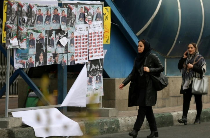Des Iraniennes circulant dans une rue de Téhéran devant des affiches électorales le 19 février 2020