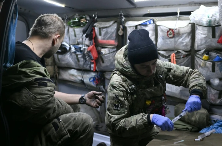 Vasylyna, assistante médicale ukrainienne pour la 80e brigade d’assaut, soigne un soldat blessé dans une fourgonnette médicalisée, dans la région de Donetsk, le 30 novembre 2023