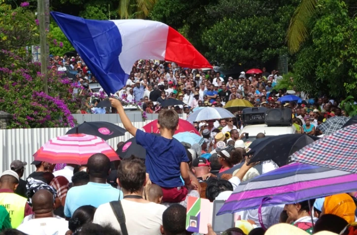 Un enfant agite un drapeau français le 19 avril 2016 à Mamoutzou pendant la marche contre la violence et l'insécurité dans le département de Mayotte à l'occasion d'une journée "île morte"