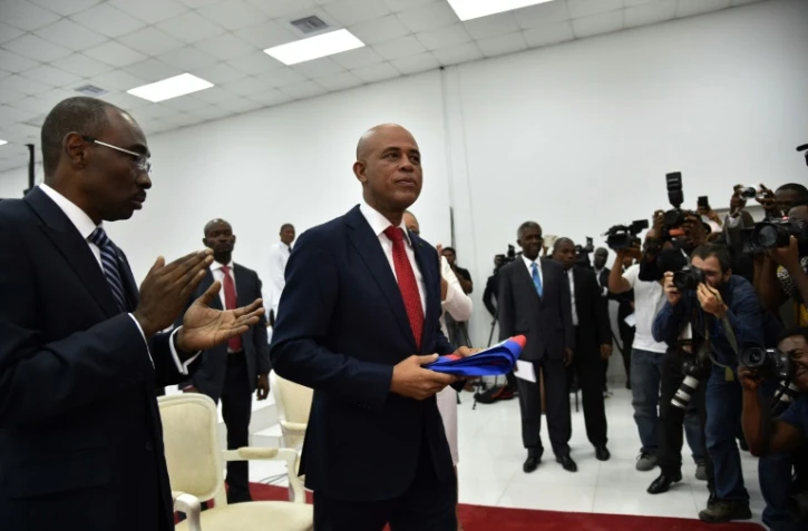 Le président haïtien Michel Martelly s'apprête à remettre son écharpe présidentielle à Jocelerme Privert, président de l'Assemblée nationale, durant une cérémonie au parlement haïtien à Port-au-Prince, le 7 février 2016