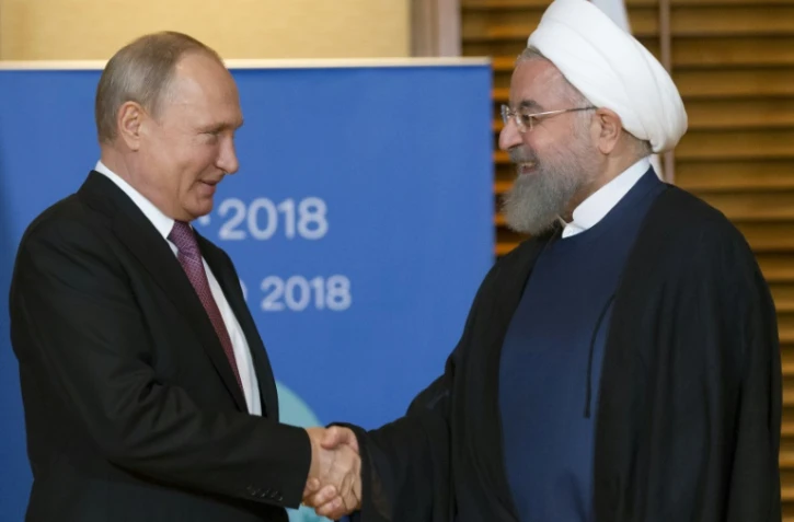 Les présidents russe Vladimir Poutine et iranien Hassan Rohani se réunissent en marge du sommet de l'Organisation de coopération de Shanghai, le 9 juin 2018 à Qingdao, en Chine