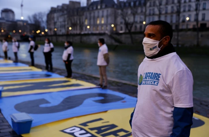 Un militant écologiste participe à une action le 14 janvier 2021 à Paris pour attirer l'attention sur le procès intenté à l'Etat par plusieurs ONG