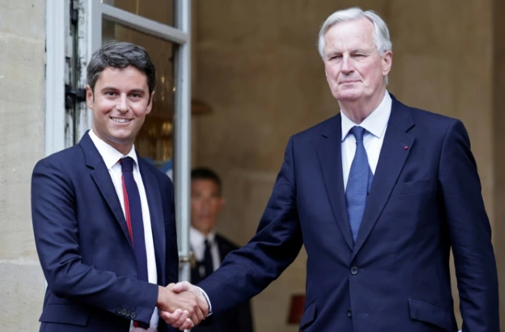 Le nouveau Premier ministre Michel Barnier (D) sur le perron de l'hôtel Matignon avec son prédécesseur Gabriel Attal le 5 septembre 2024 à Paris