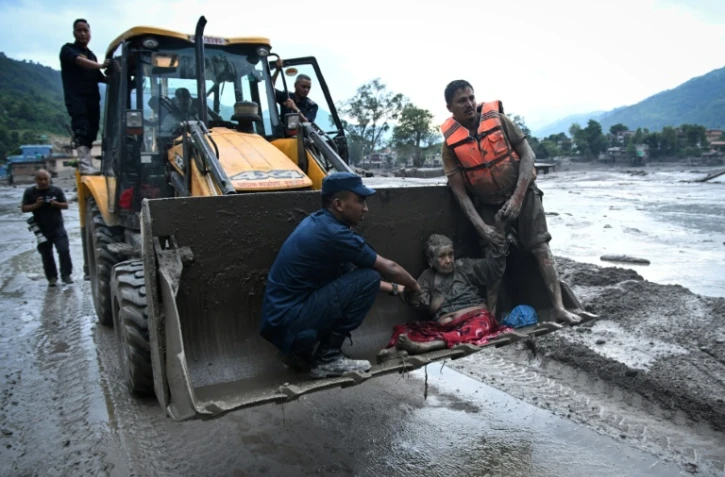 Les secouristes évacuent une personne ayant survécu à la crue soudaine à Devghat, dans le district de Nuwakot au Népal, le 26 août 2026