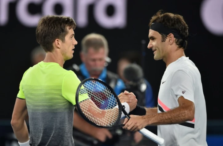 Le Suisse Roger Federer serre la main du Slovène Aljaz Bedene qu'il a battu au 1er tour de l'Open d'Australie le 16 janvier 2018