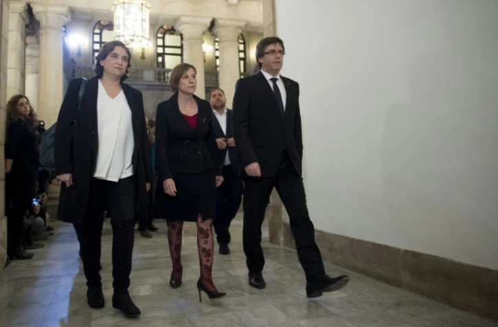 La maire de Barcelone, Ada Colau (G), la présidente du parlement catalan Carme Forcadell et le président du gouvernement catalan Carles Puigdemont (D) avant une réunion à Barcelone, le 23 décembre 2016 