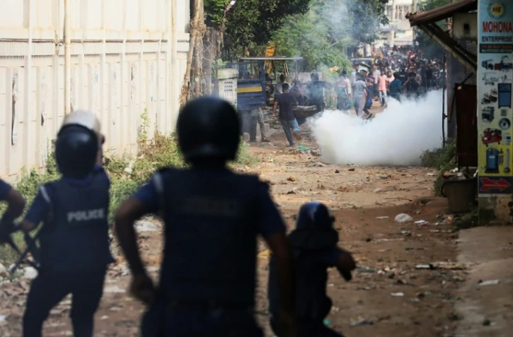 La police a tiré des grenades lacrymogènes pour disperser les ouvriers du textile qui organisent un rassemblement pour exiger un quasi-triplement de leur salaire à Ashulia le 4 novembre 2023