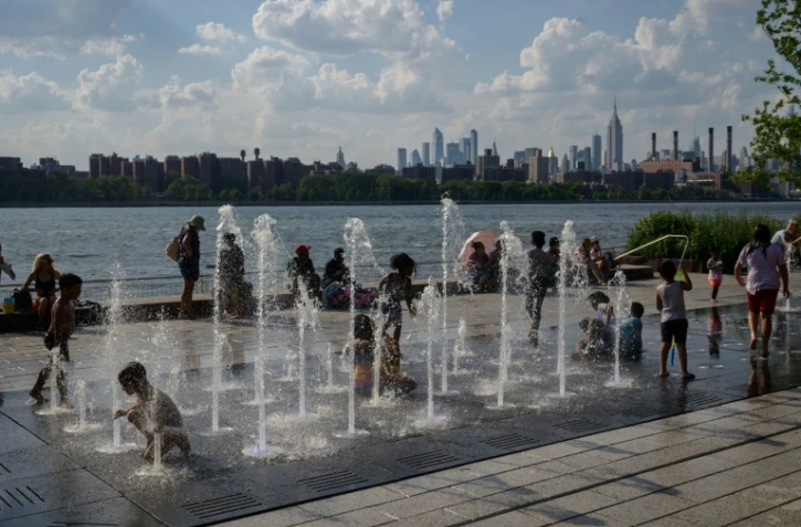 Des enfants se rafraîchissent dans une fontaine, le 30 juin 2021 à New York